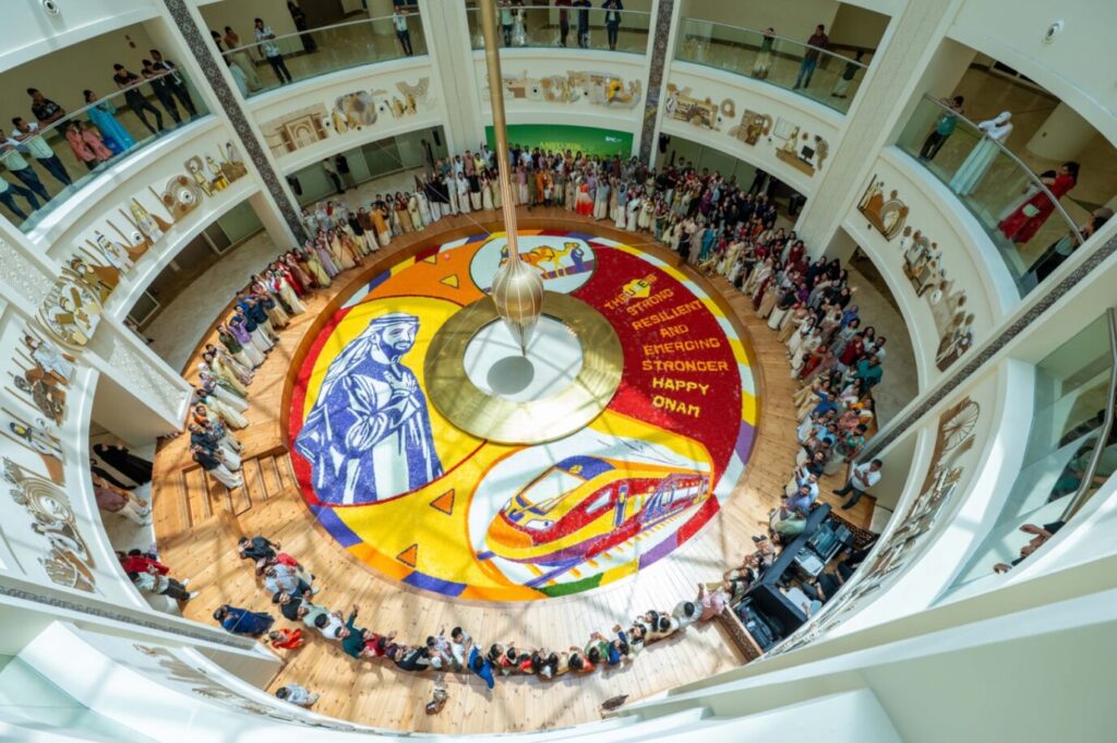 Healthcare workers at Burjeel Medical City standing around a 250-square-meter floral carpet featuring UAE President Sheikh Mohamed bin Zayed Al Nahyan.