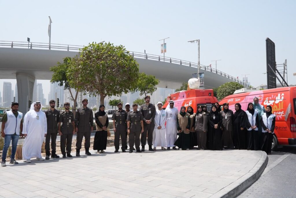 GDRFA officers distributing cold drinking water and refreshments to outdoor workers in Dubai during summer.