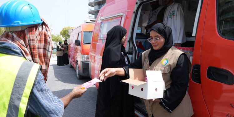 GDRFA officers distributing cold drinking water and refreshments to outdoor workers in Dubai during summer.