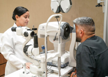 Optometrist conducting a digital eye test for a driving licence applicant in Dubai.