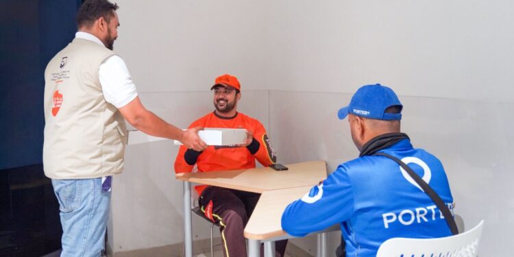 Delivery riders receiving meals at a Dubai metro station rest area during the summer midday break.
