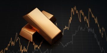 Stack of gold bullion bars and financial market trading screen display